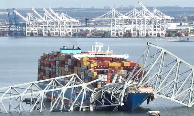 Parte del puente colapsado encima del buque de carga