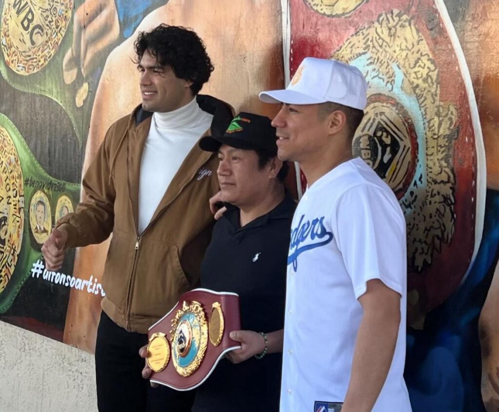 Gilberto "Zurdo" Ramírez posa junto a Jessie Vargas y su campeonato mundial de peso crucero frente a su mural