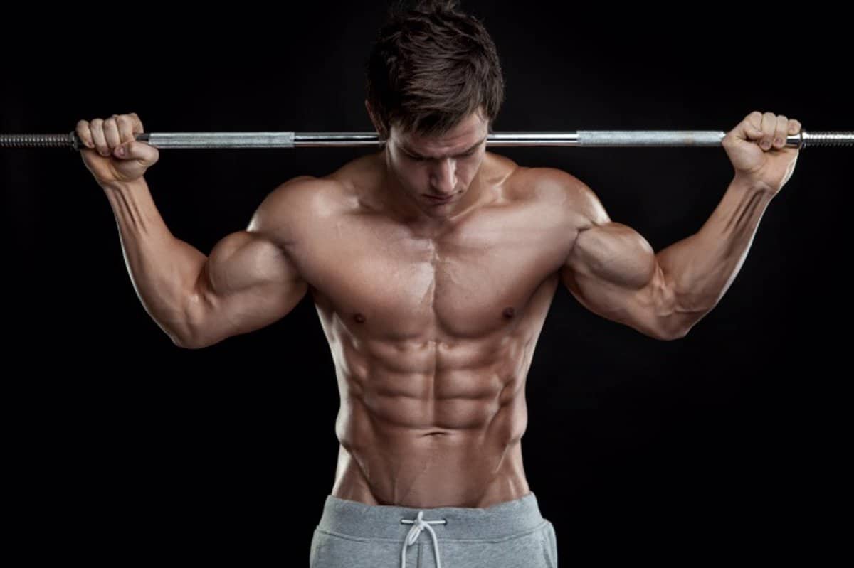 Hombre musculoso sosteniendo una barra de metal