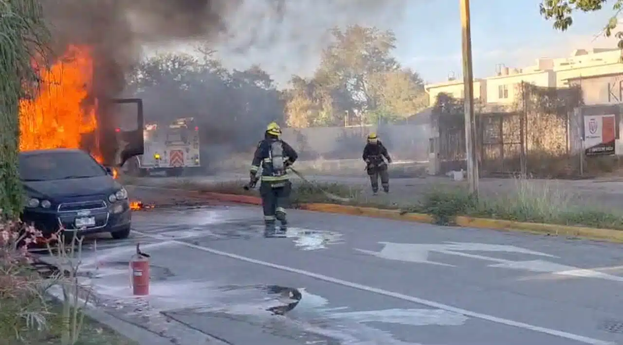 Bombero apagando las llamas de un automóvil.