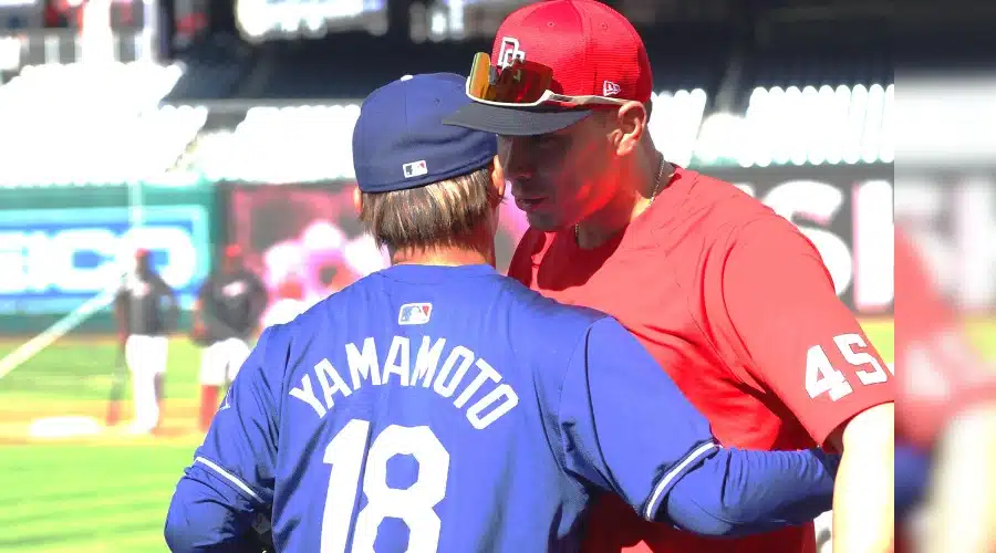 Joey Meneses y Yoshinobu Yamamoto se saludan antes del juego entre Los Ángeles Dodgers y Nacionales de Washington
