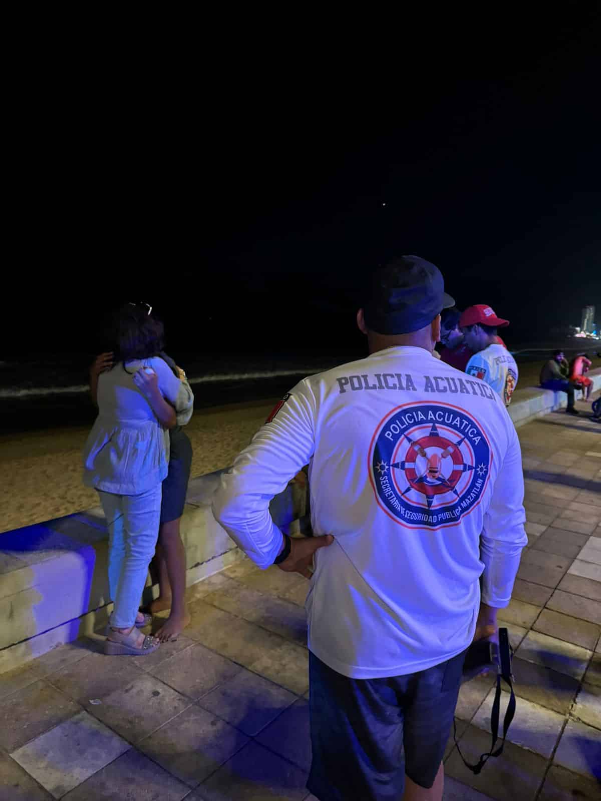 Jorge abrazando a su mamá y un elemento de Protección Civil en el malecón de Mazatlán