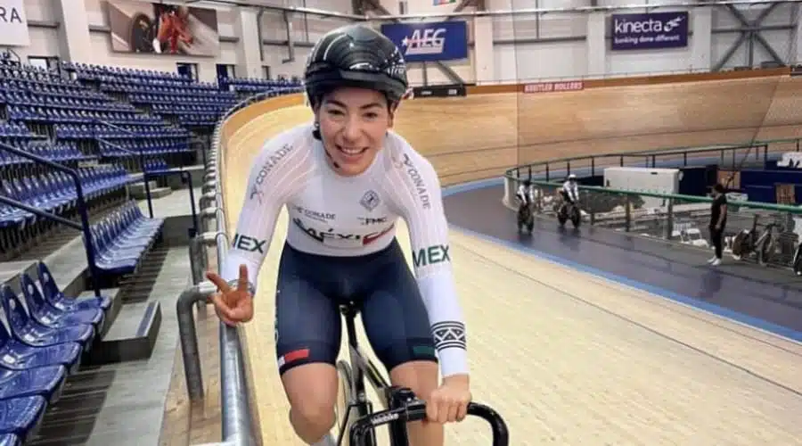 La ciclista Luz Daniela Gaxiola saluda con los dedos haciendo el símbolo de paz desde su bicicleta en el velódromo