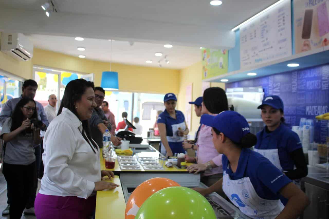 Personas atrás de un mostrador en la Dolphy atendiendo a otras que llegan a comprar una nieve en la sucursal de Badiraguato