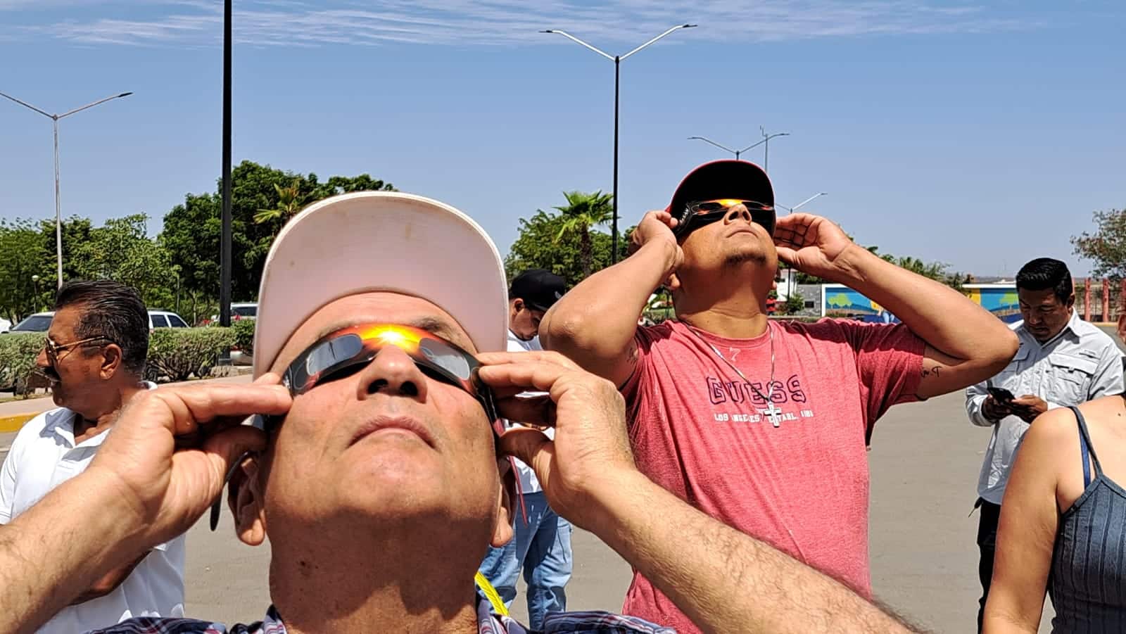 Personas en la presa Eustaquio Buelna mirando al cielo para apreciar el eclipse total de Sol en Guamúchil