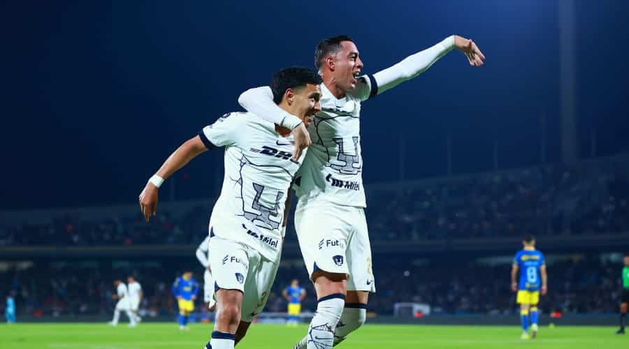 Rogelio Funes Mori abrazando a un compañero de futbol del equipo de Pumas de la liga MX en el estadio de Ciudad Universitaria en México