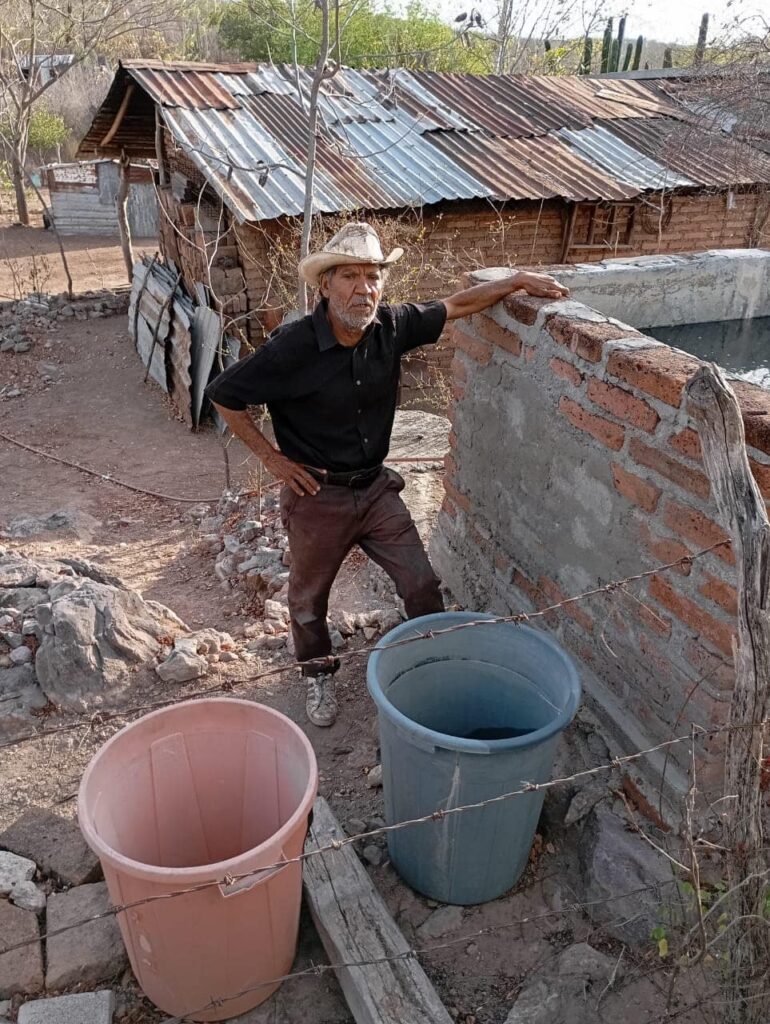 Vecino de una comunidad de El Fuerte con dos cubetas que llenará con agua