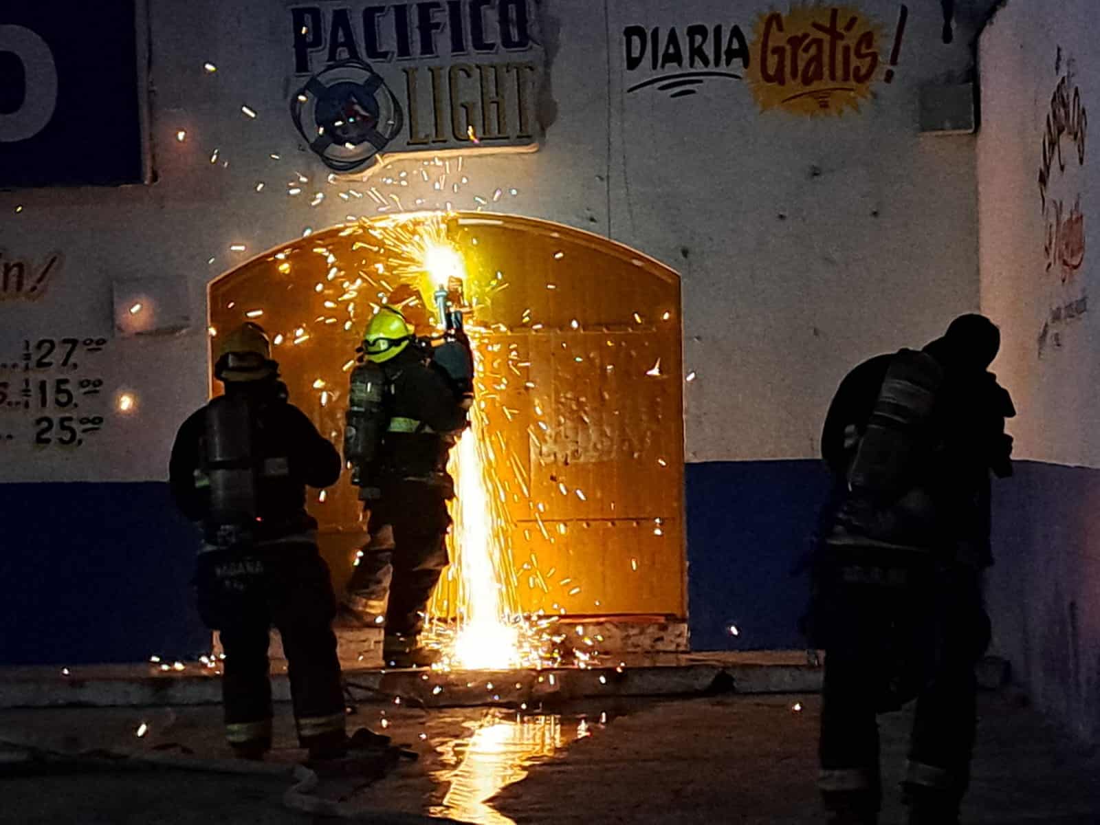 BOmberos en el bar incendiado