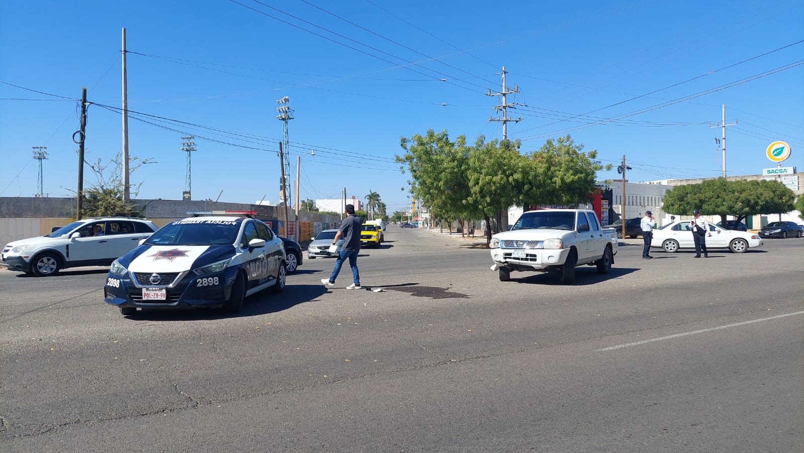 Automóvil dela marca Nissan tipo pick up de color blanco y transito municipal en el lugar del accidente.