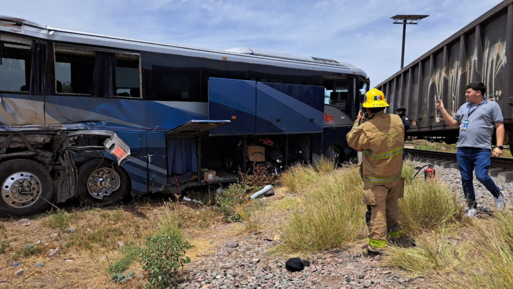 Bomberos en zona de accidente entre tren y autobús