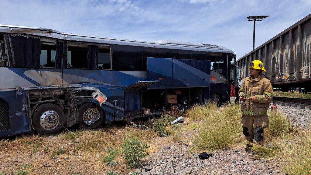 Bomberos en zona de accidente entre tren y autobús