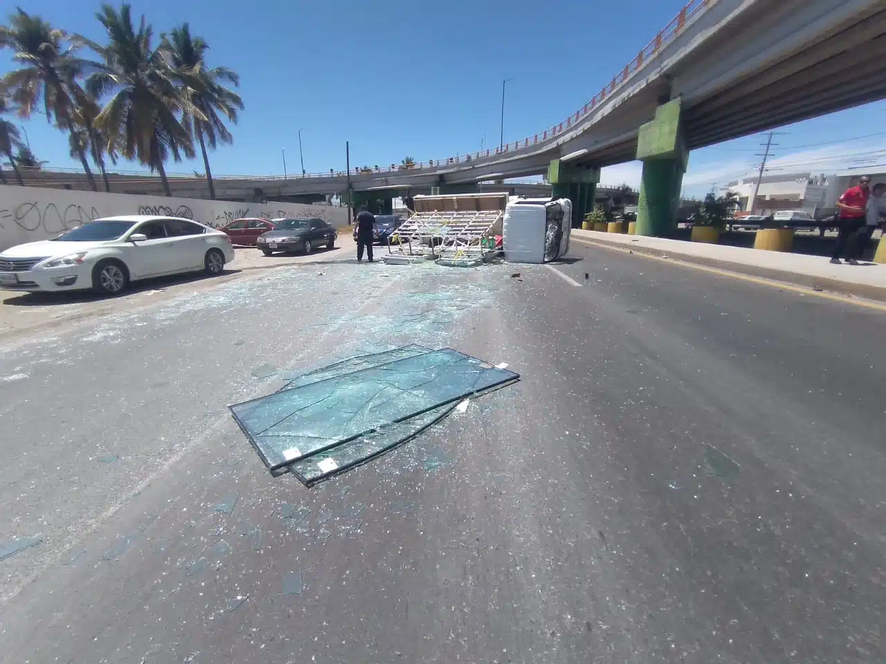 Camión cargado de vidrio vuelca en una curva en Mazatlán.