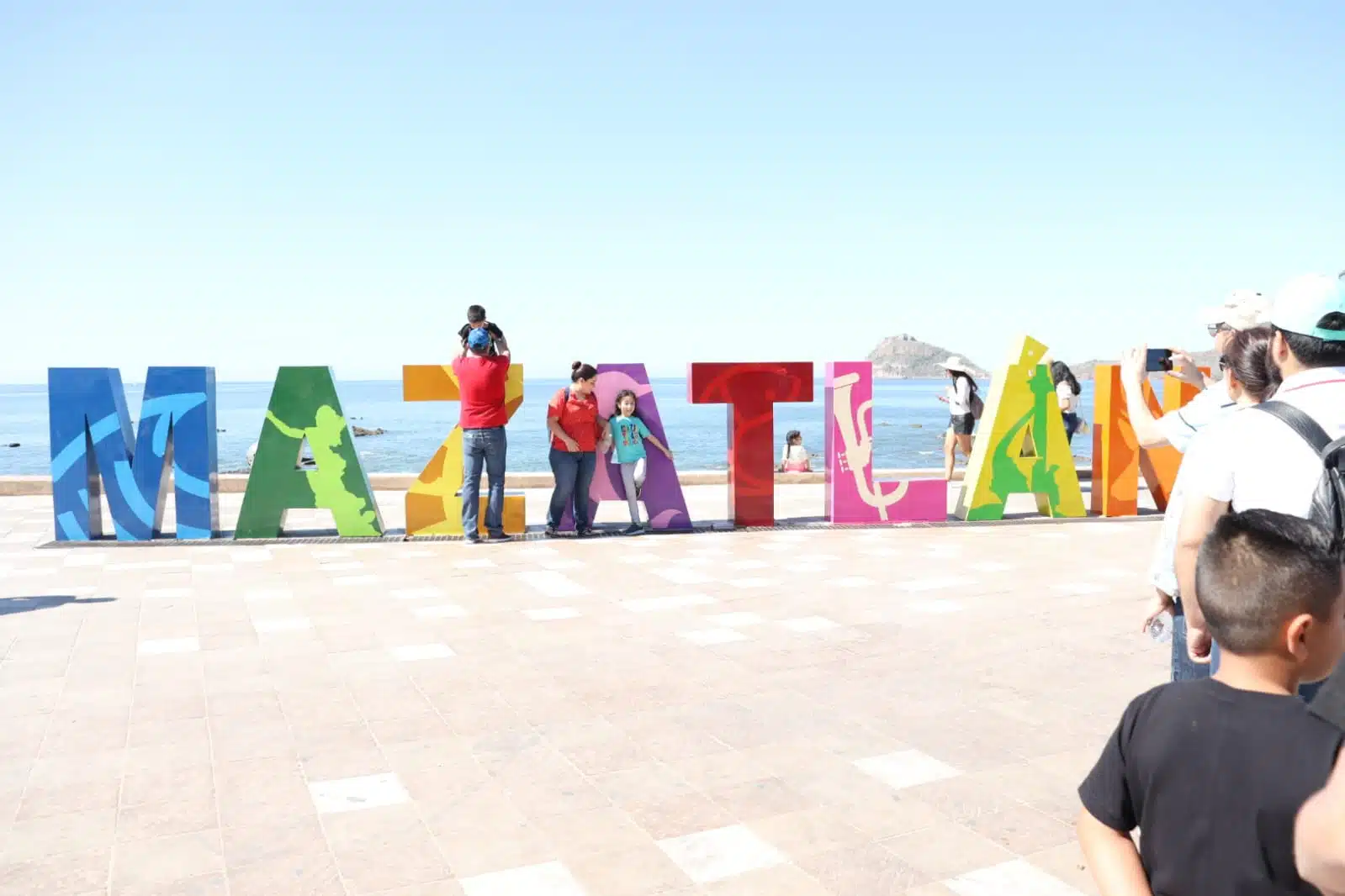 Visitantes tomándose fotografías en las coloridas letras de Mazatlán