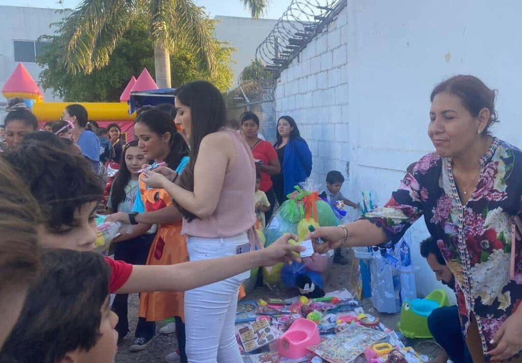 Persona entrega bollito a niño durante festejo en Los Mochis