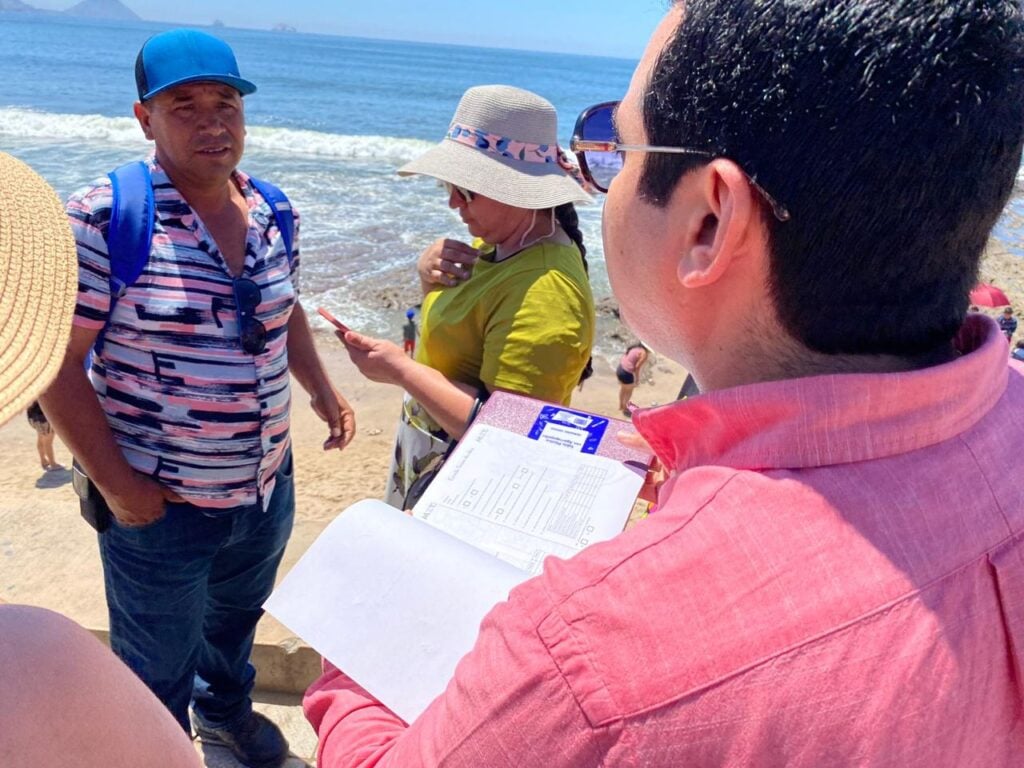 Persona encuestando a turista en playa