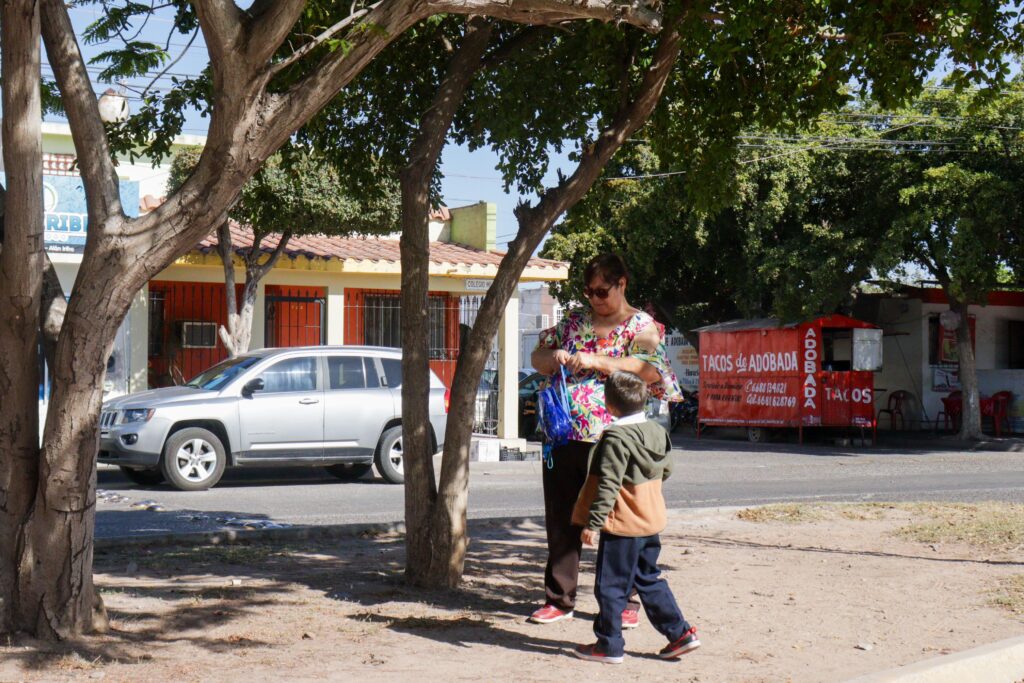 Madre lleva a su hijo a la escuela