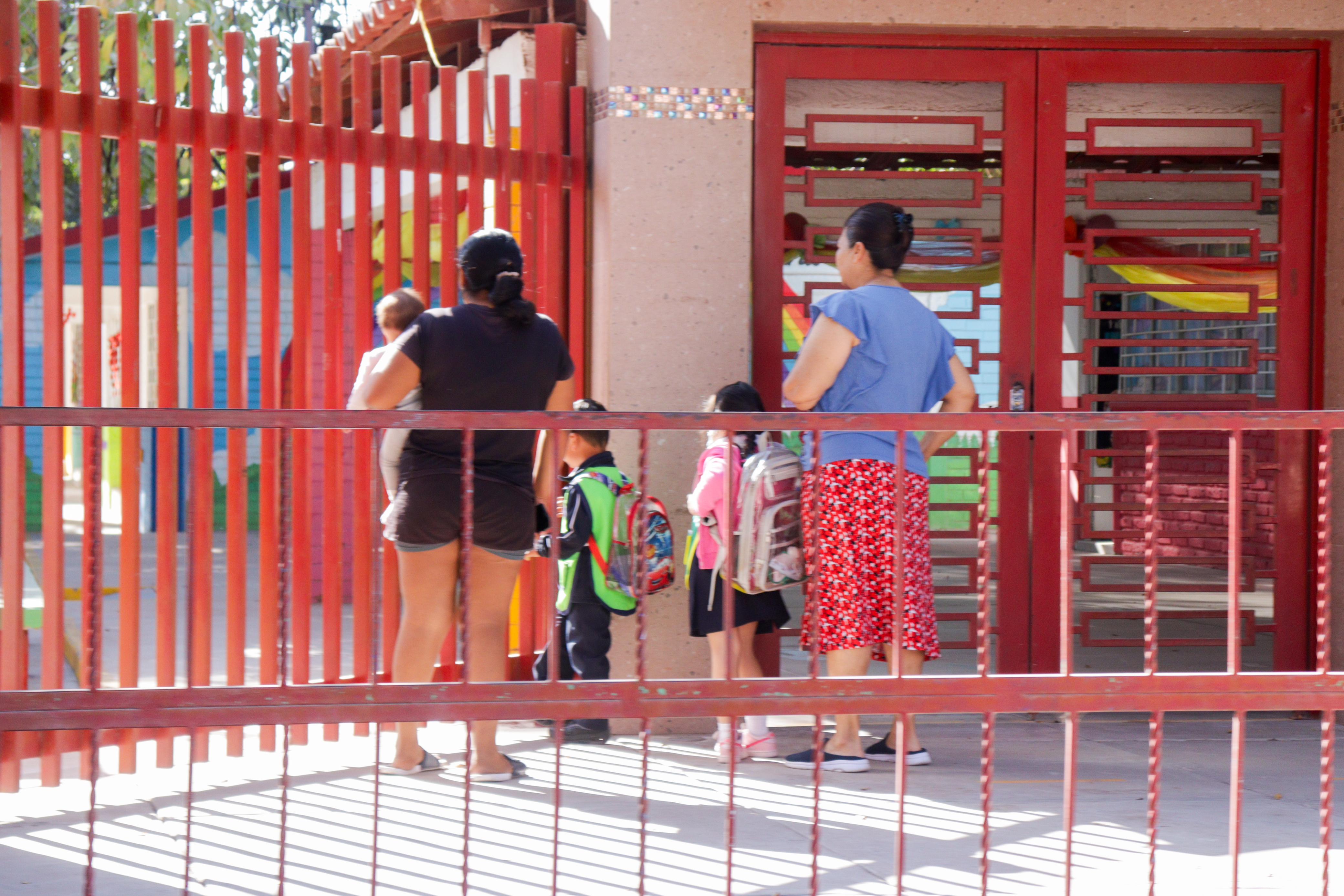 Madres llevan a sus hijos a la escuela