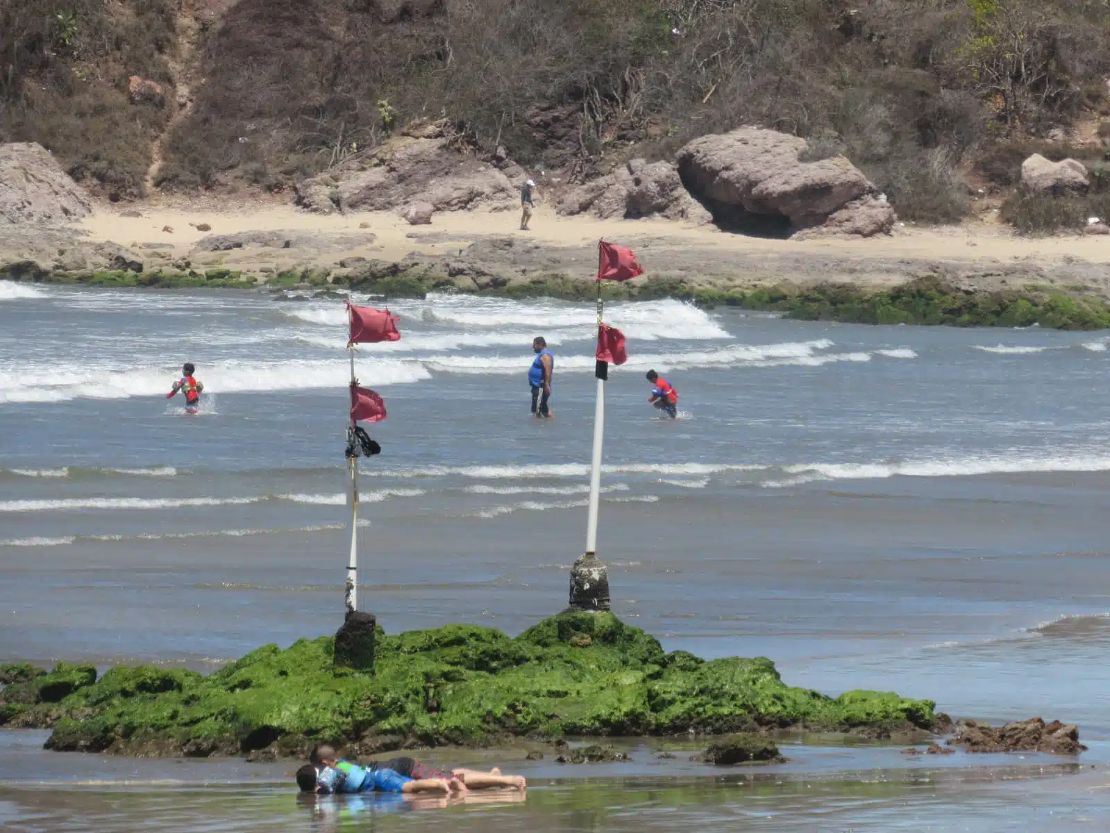 Turistas en playa de Mazatlán con banderillas rojas