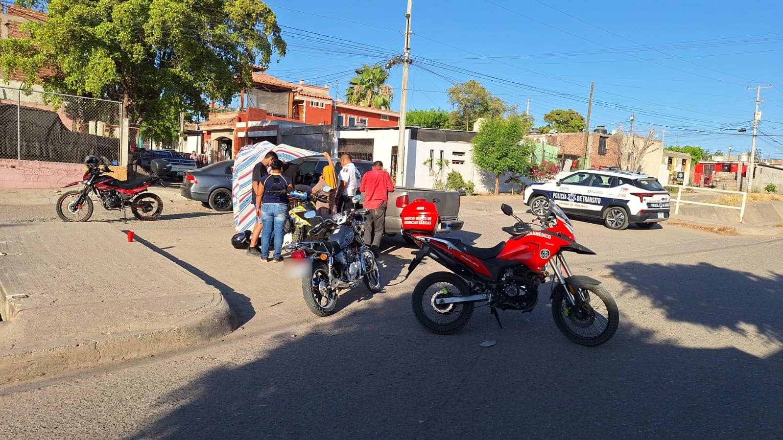 Personas en el lugar donde un joven motociclista chocó contra una camioneta en Culiacán