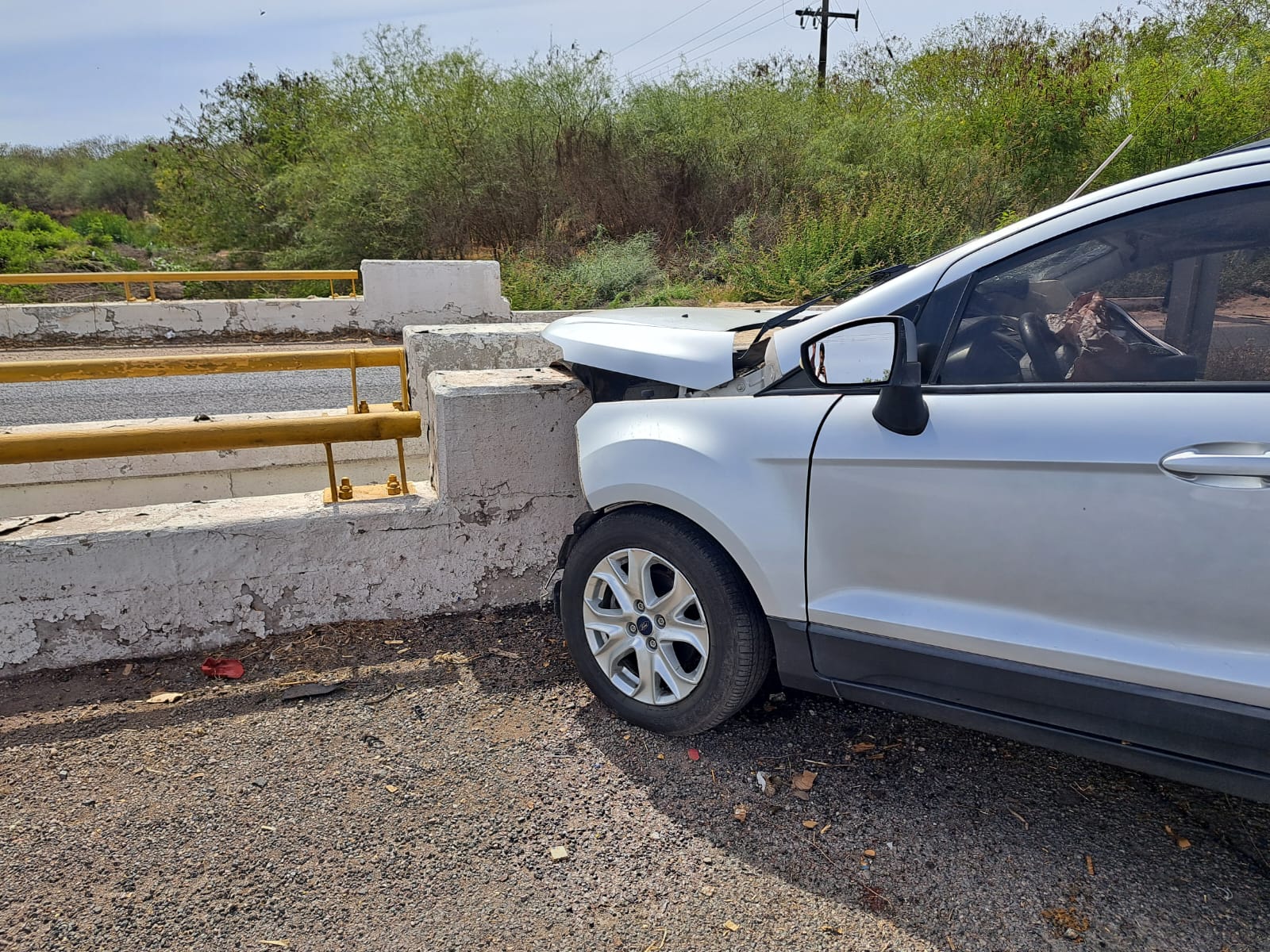 Camioneta destrozada del frente tras un accidente tipo choque contra el muro de contención en la carretera Culiacán-Eldorado