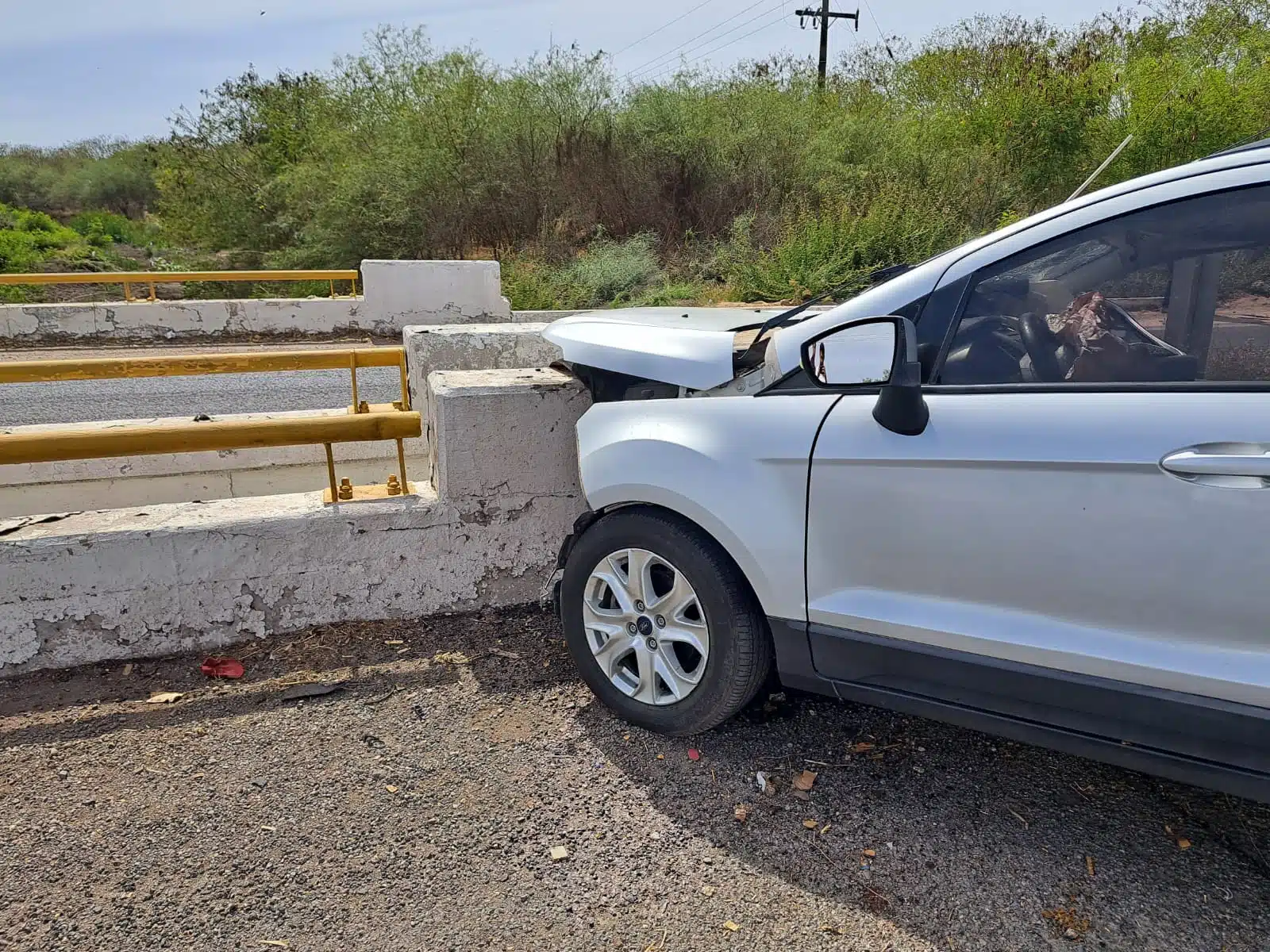 Camioneta destrozada del frente tras un accidente tipo choque contra el muro de contención en la carretera Culiacán-Eldorado