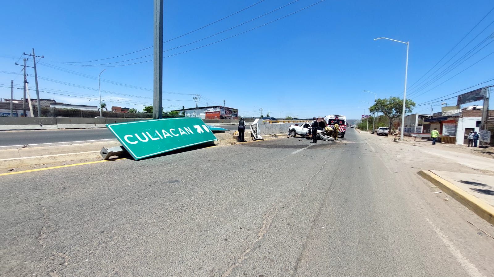 Camioneta destrozada de un lado tras un accidente tipo choque en la que viajaba Ángel y una ambulancia de la Cruz Roja en la carretera sobre el libramiento Benito Juárez "La Costerita" en Culiacán