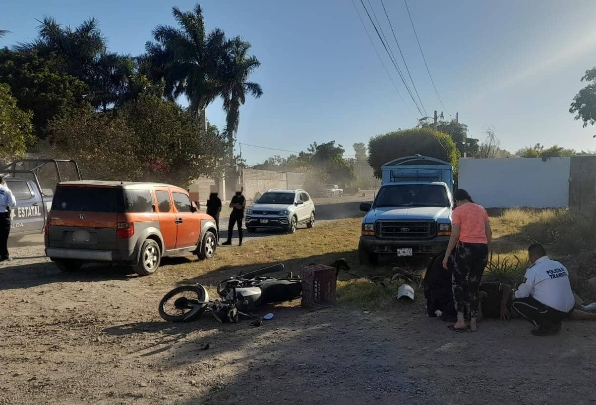 Lugar donde ocurrió el accidente. Hay una motocicleta tirada y un hombre está siendo auxiliado