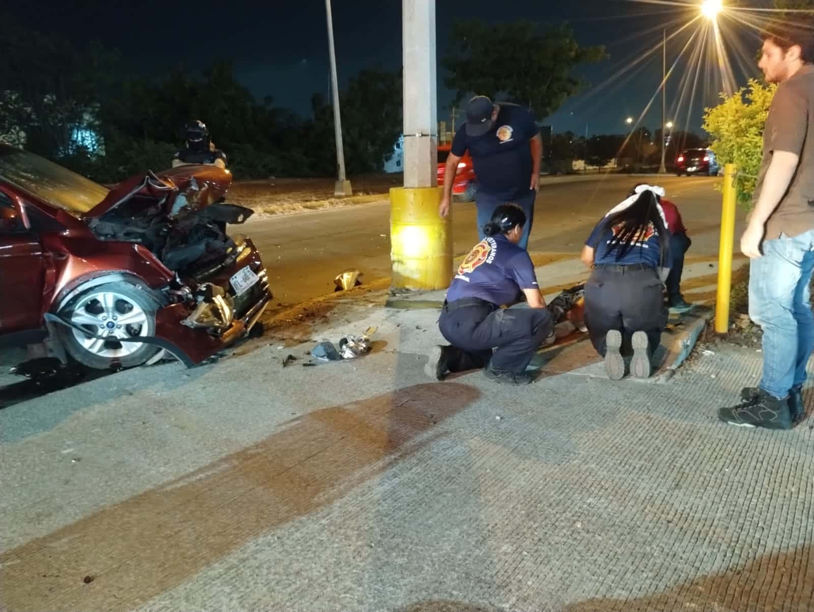 Personal de Bomberos Veteranos Mazatlán auxiliando a la joven mujer que resultó herida