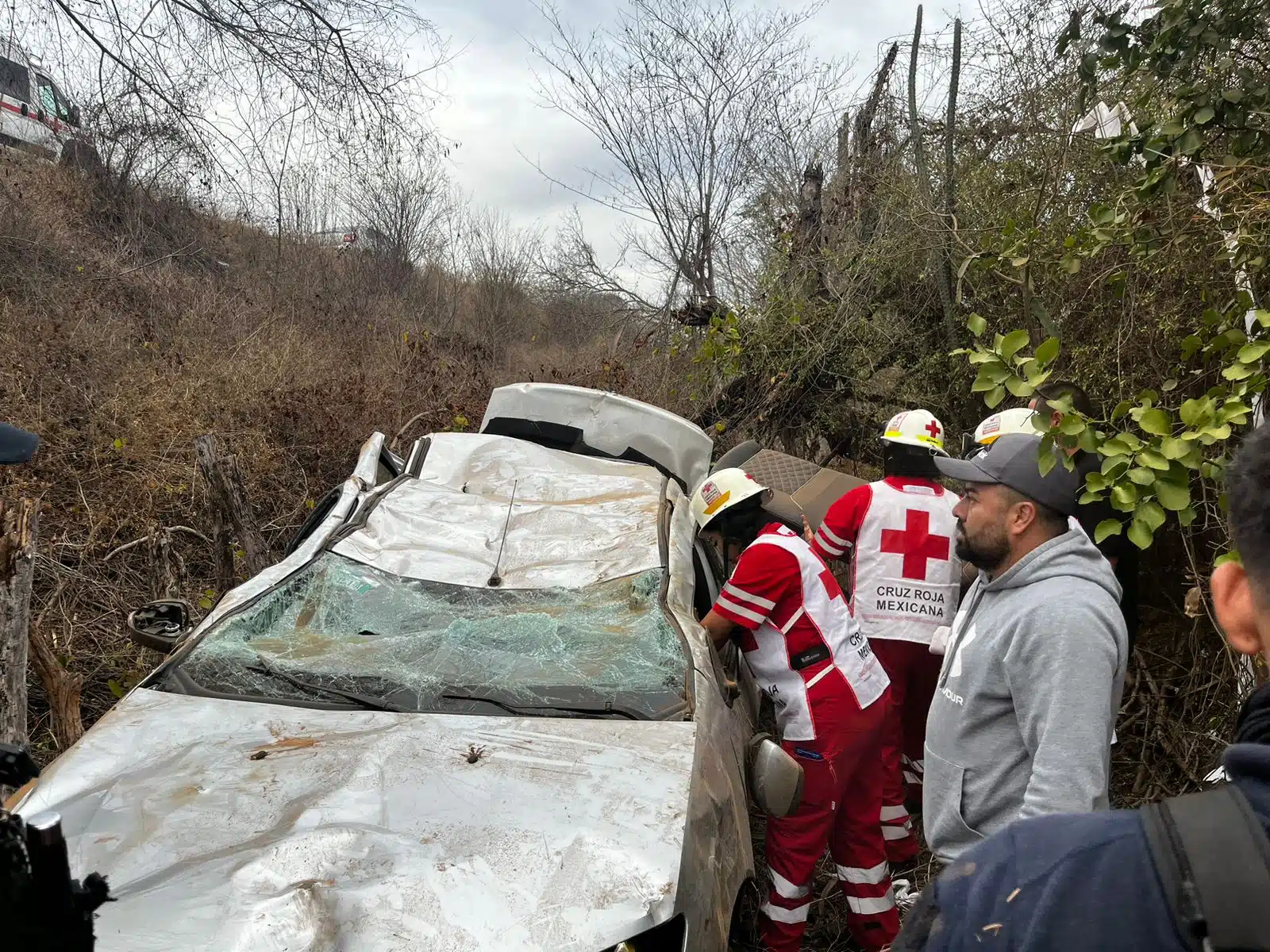 Carro volcado al fondo de un barranco tras un accidente y elementos de la Cruz Roja en el lugar por la carretera Mazatlán-Culiacán