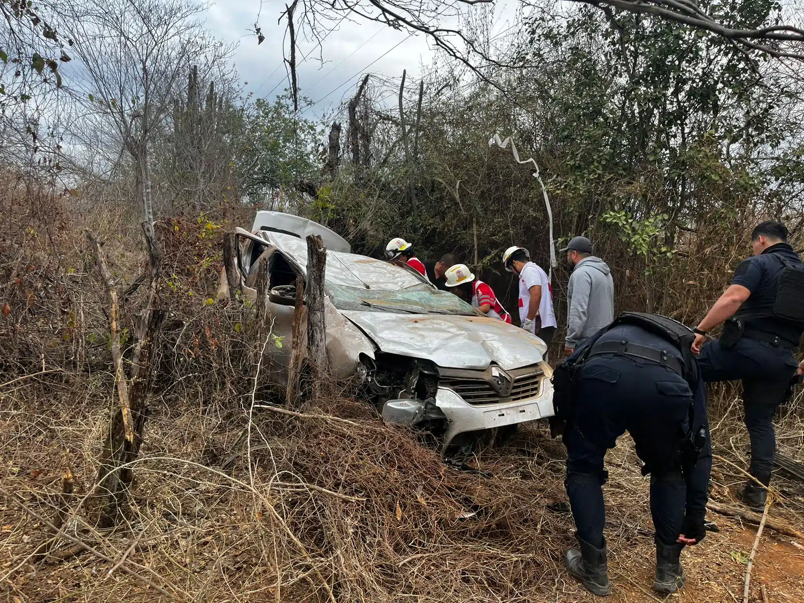 Carro volcado al fondo de un barranco tras un accidente y elementos de la Cruz Roja en el lugar por la carretera Mazatlán-Culiacán