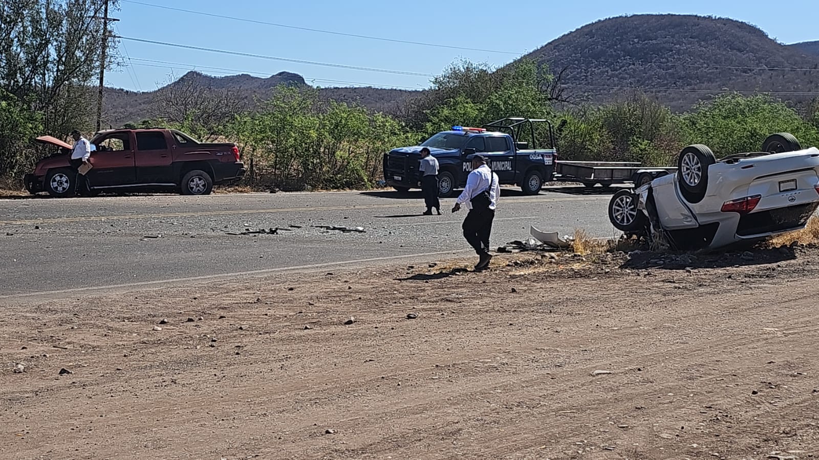 Carro volcado con los neumáticos hacia arriba, en el que viajaba una mujer que quedó herida, tras un accidente por la carretera Guamúchil-Mocorito y atrás una camioneta con la que chocó
