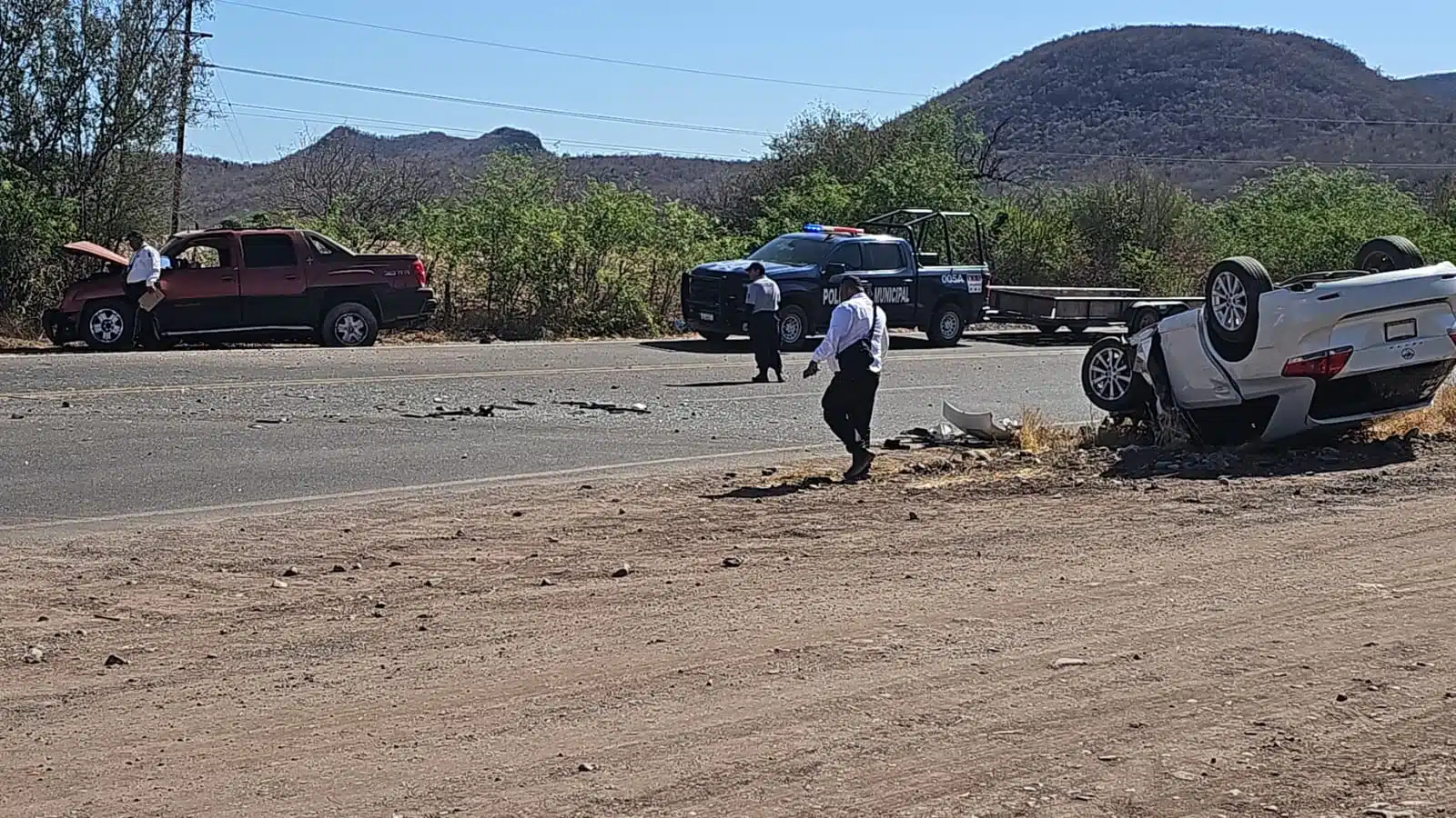Carro volcado con los neumáticos hacia arriba, en el que viajaba una mujer que quedó herida, tras un accidente por la carretera Guamúchil-Mocorito y atrás una camioneta con la que chocó