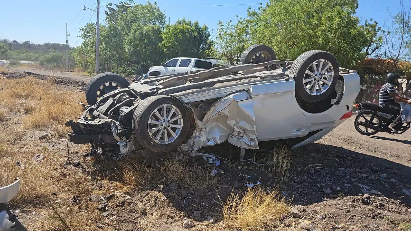 Carro volcado con los neumáticos hacia arriba, en el que viajaba una mujer que quedó herida, tras un accidente por la carretera Guamúchil-Mocorito