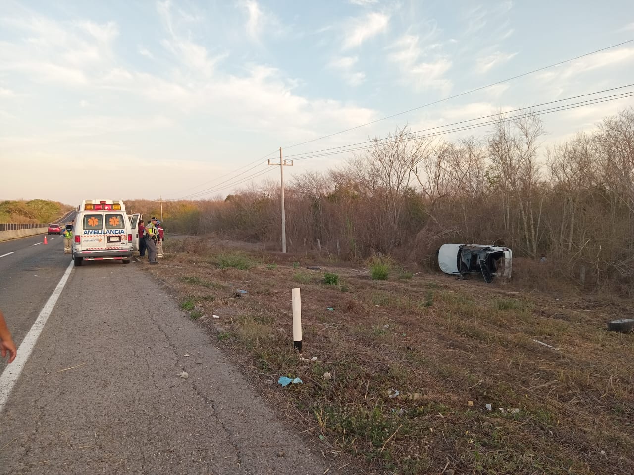 Carro volcado con los neumáticos hacia un lado tras un accidente tipo salida de camino en la autopista Mazatlán-Culiacán