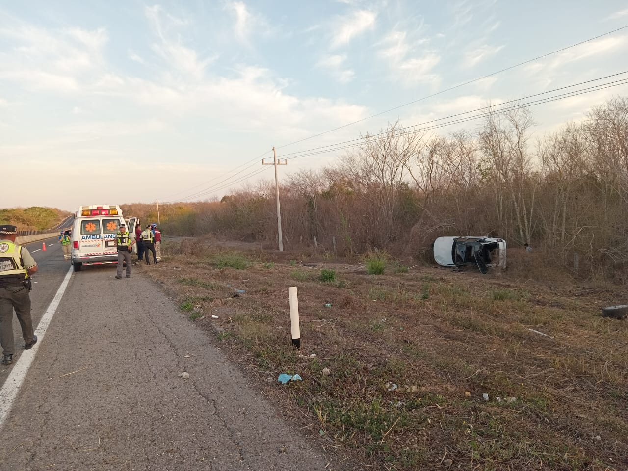 Carro volcado con los neumáticos hacia un lado tras un accidente tipo salida de camino en la autopista Mazatlán-Culiacán