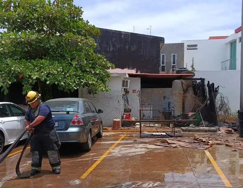 Bombero apagando el fuego en una taquería de Culiacán