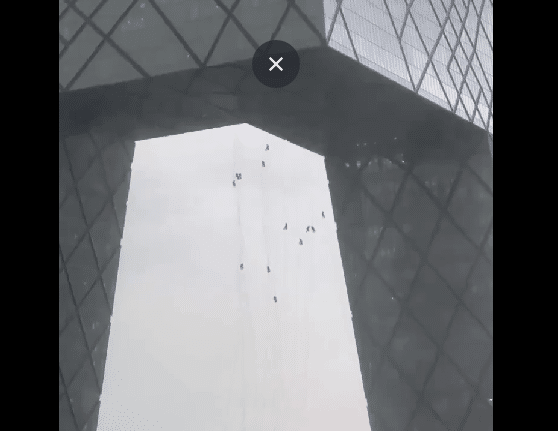 Trabajadores colgando en edificio de Beijing