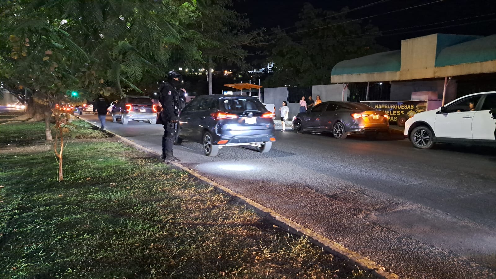 Carros estacionados que fueron afectados por ponchallantas que tiraron sobre la avenida Álvaro Obregón en Culiacán y otros pasando por ahí