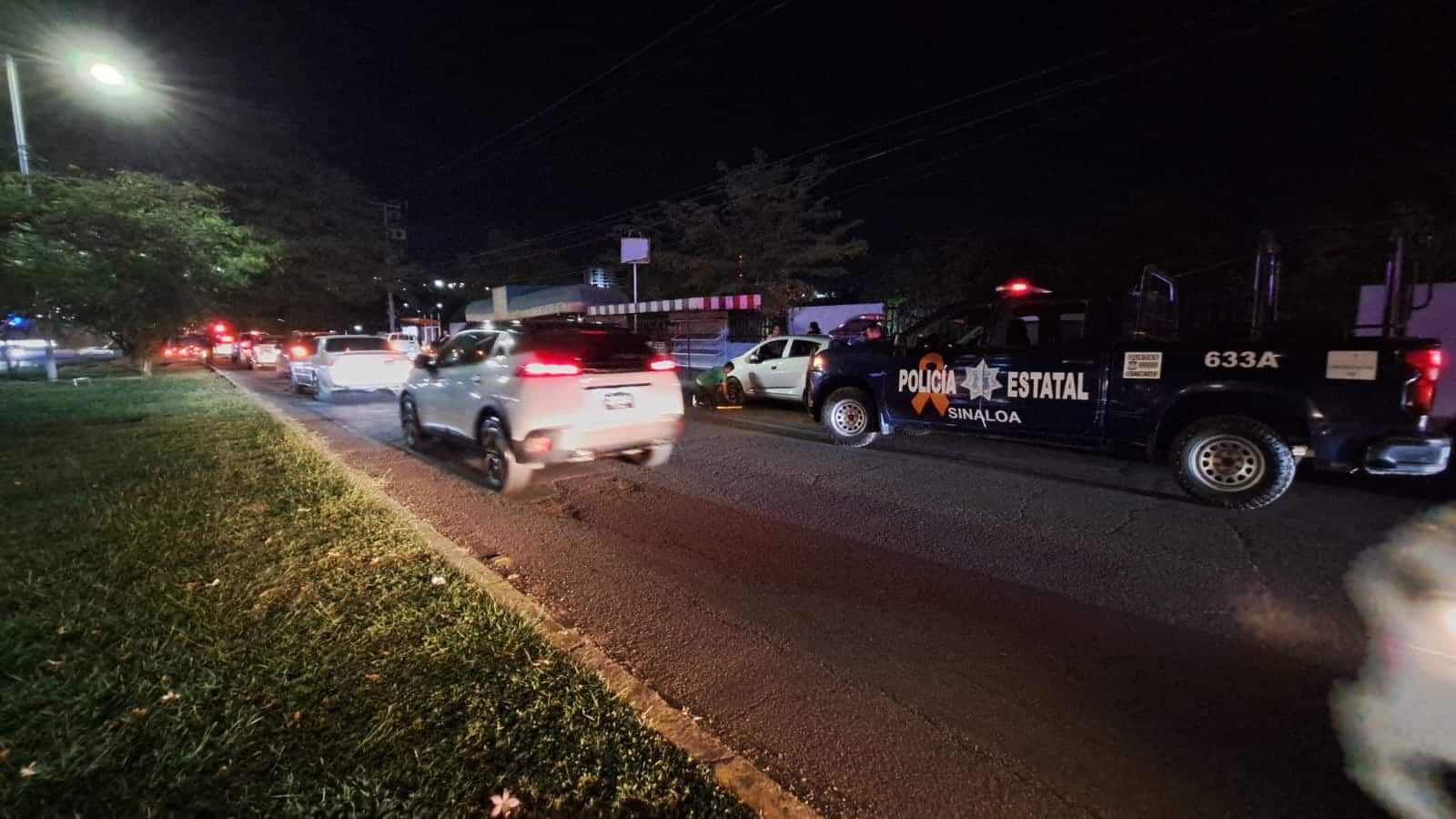 Carros estacionados que fueron afectados por ponchallantas que tiraron sobre la avenida Álvaro Obregón en Culiacán y otros pasando por ahí