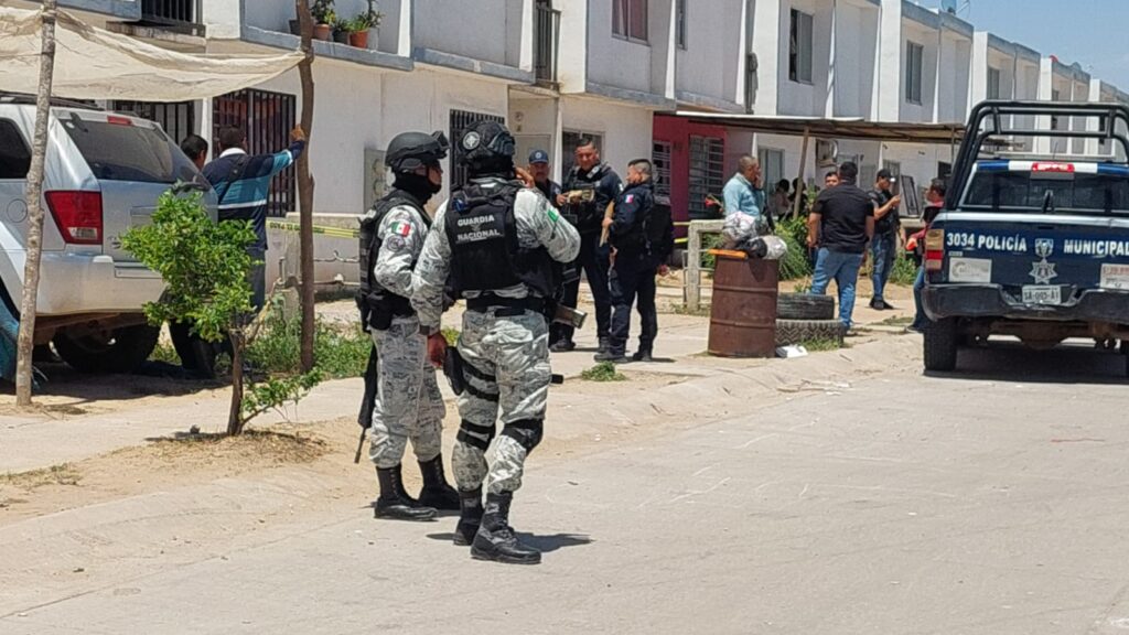 Elementos de la Guardia Nacional a fuera de una casa donde asesinaron a un hombre y dos mujeres en el fraccionamiento San Fermín en Culiacán