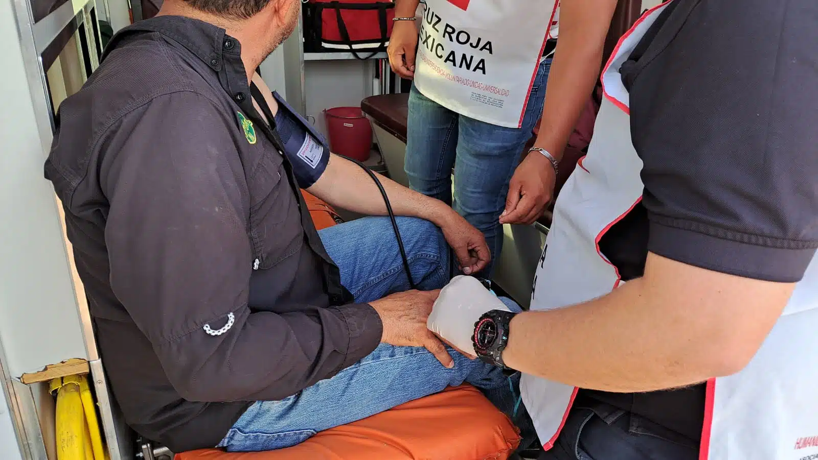 Ambulancia y elementos de la Cruz Roja atendiendo a un empleado que le picaron las abejas en una bodega de granos ubicada por la carretera Guamúchil-Angostura