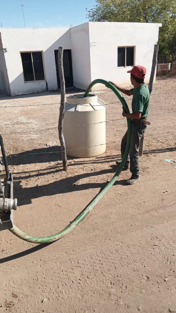 Una persona llenando de agua un tinaco por la sequía en El Fuerte