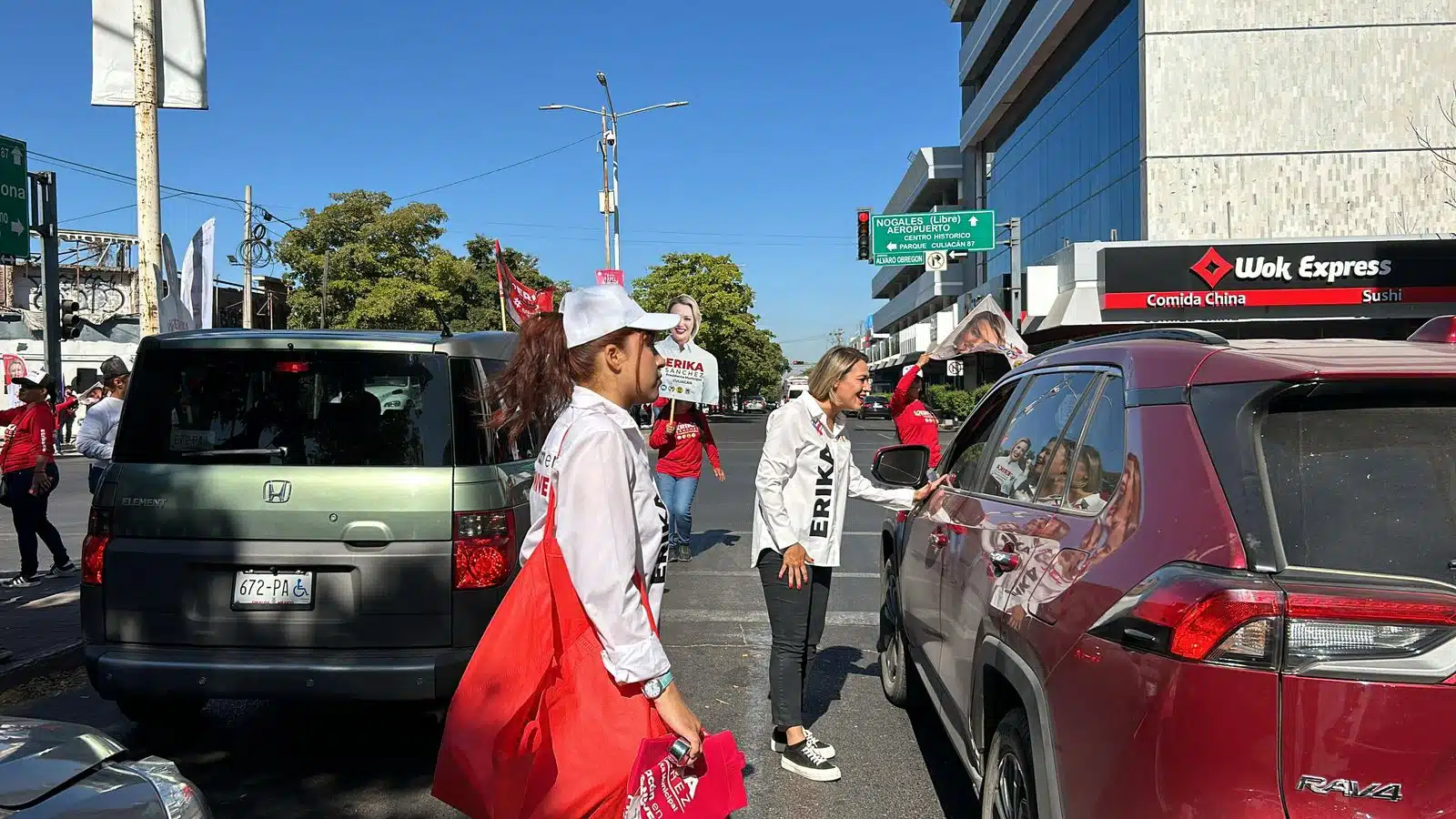 Érika Sánchez saludando a los automovilistas en el crucero de Madero y Obregón