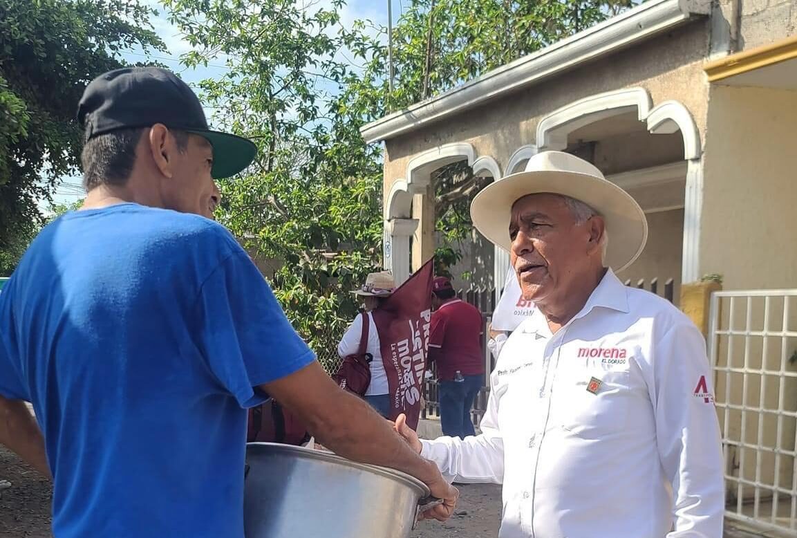 Faustino Torres Núñez estrechando la mano con un vecino de Eldorado