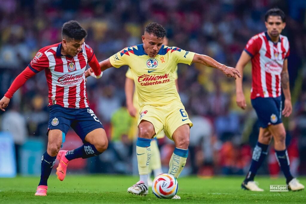 Jonathan Dos Santos jugador del América disputándose un balón con Fernando Beltrán de Chivas