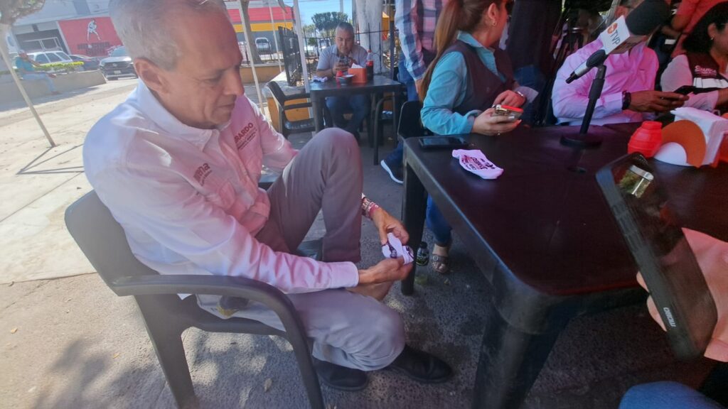Gerardo Vargas Landeros, candidato a la presidencia municipal de Ahome por el partido de Morena, poniéndose unas calcetas de las que entregó durante su campaña
