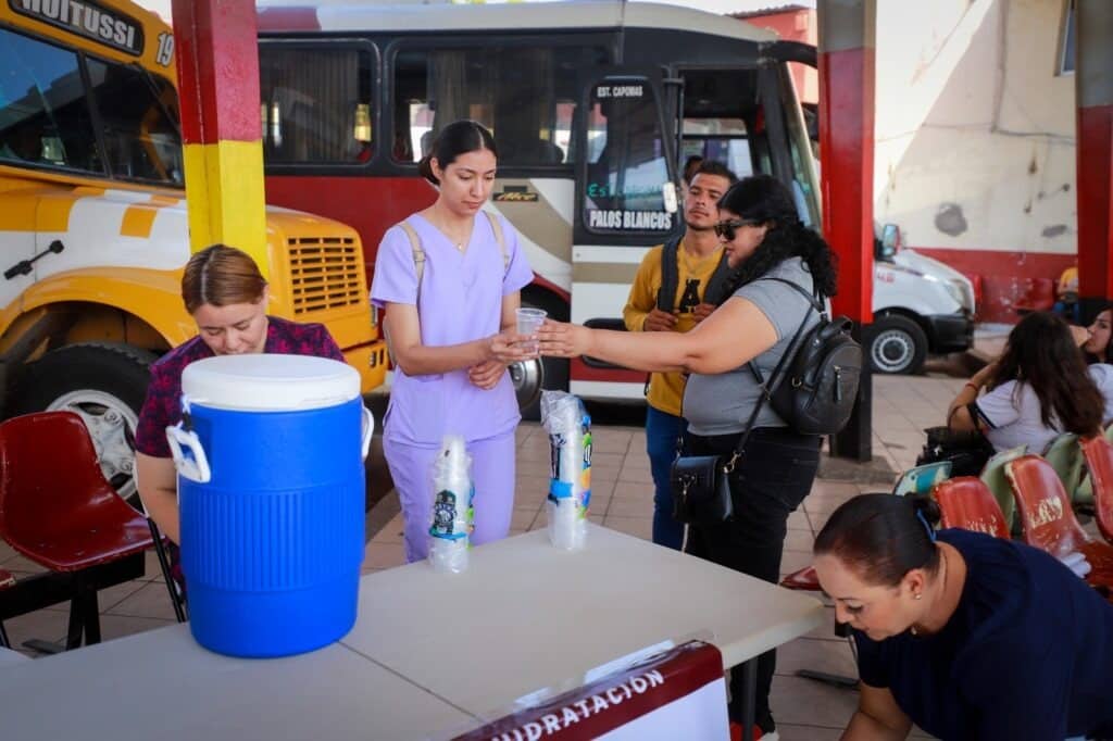 Personas en la central regional camionera de Guasave en un punto de hidratación