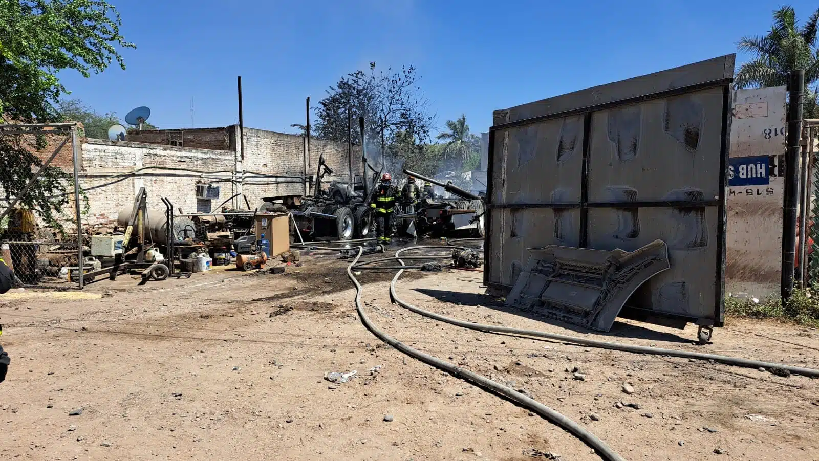 Elementos de bomberos en el lugar donde se incendiaron tres tractocamiones en Culiacán