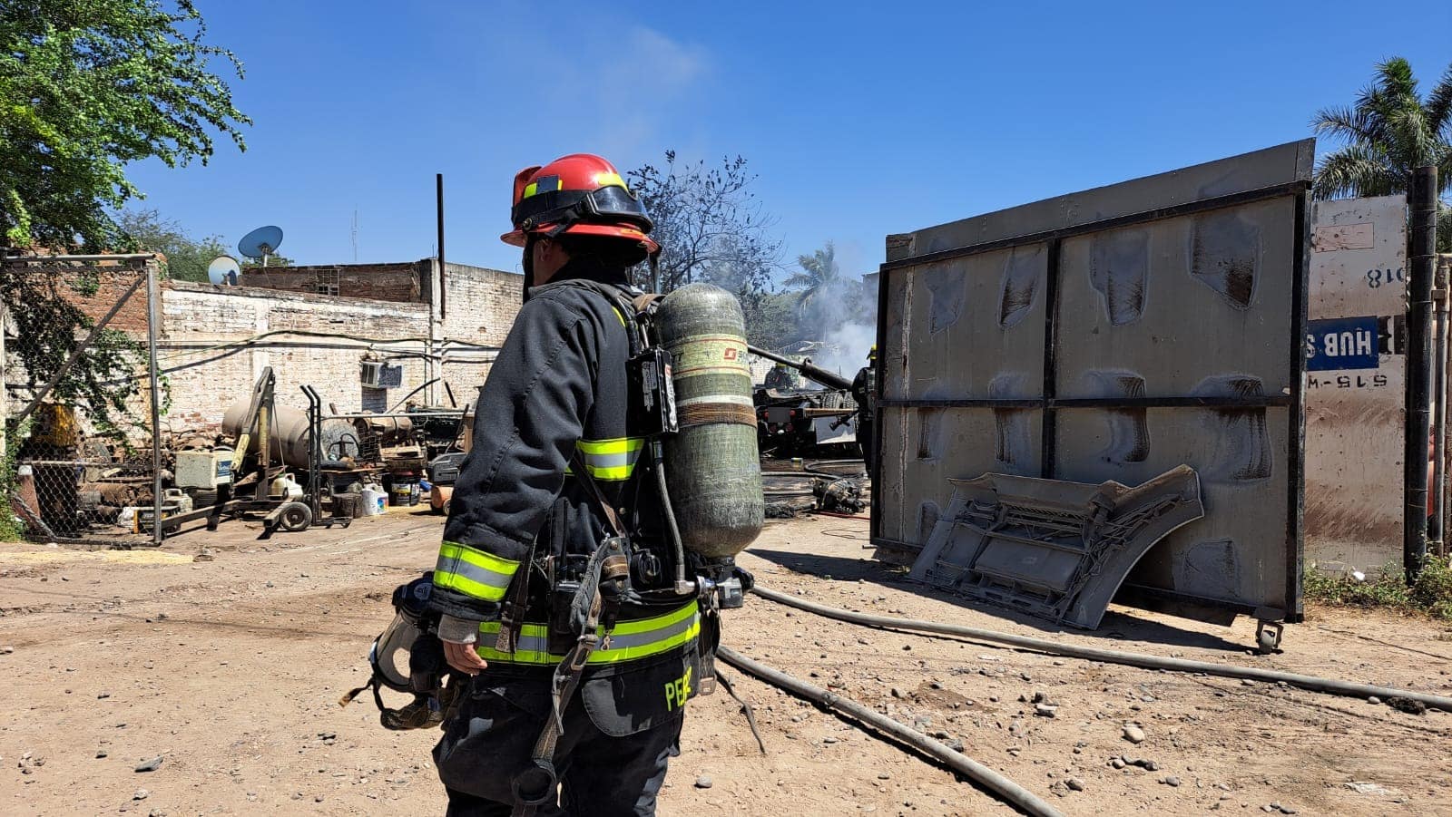 Elementos de bomberos en el lugar donde se incendiaron tres tractocamiones en Culiacán