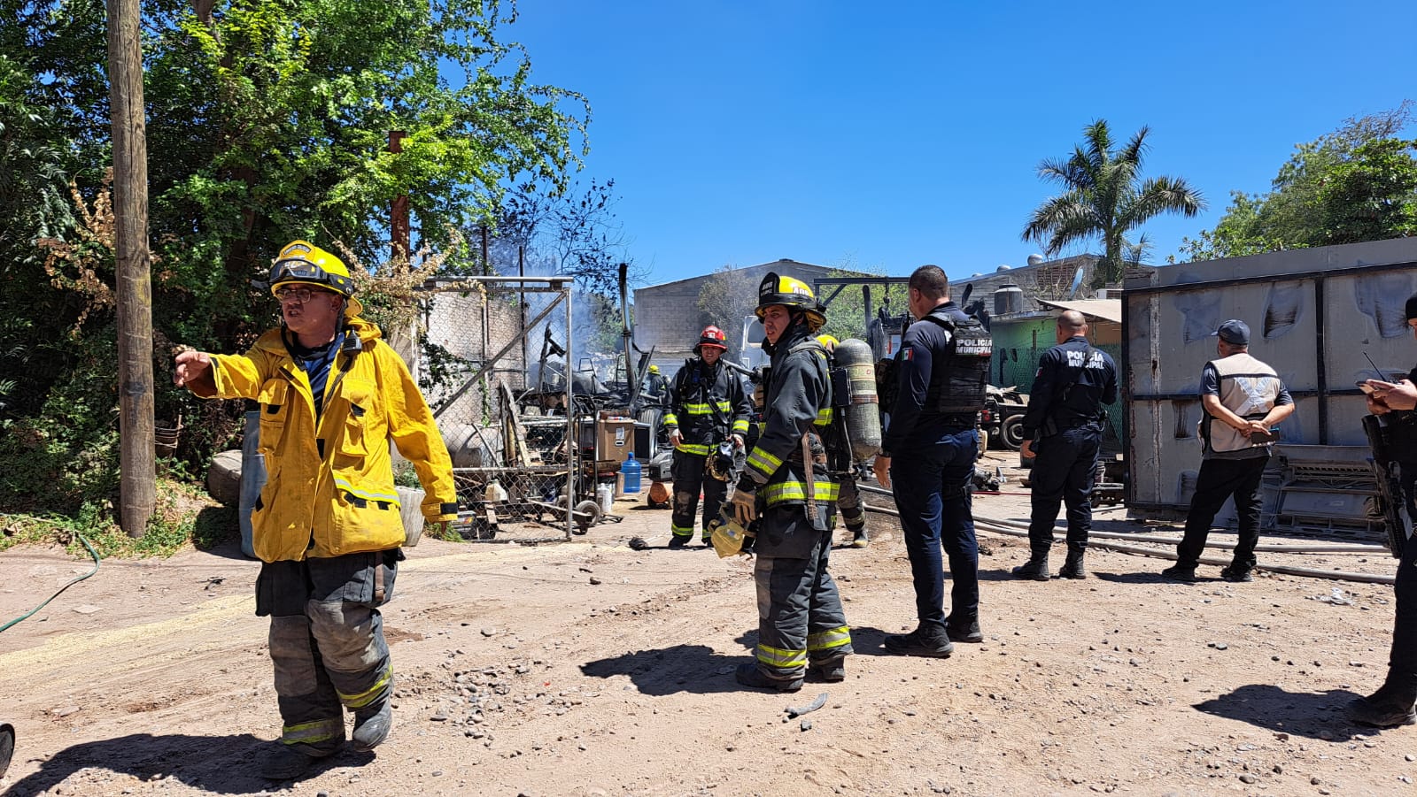 Elementos de bomberos y policía municipal en el lugar donde se incendiaron 3 tractocamiones en Culiacán